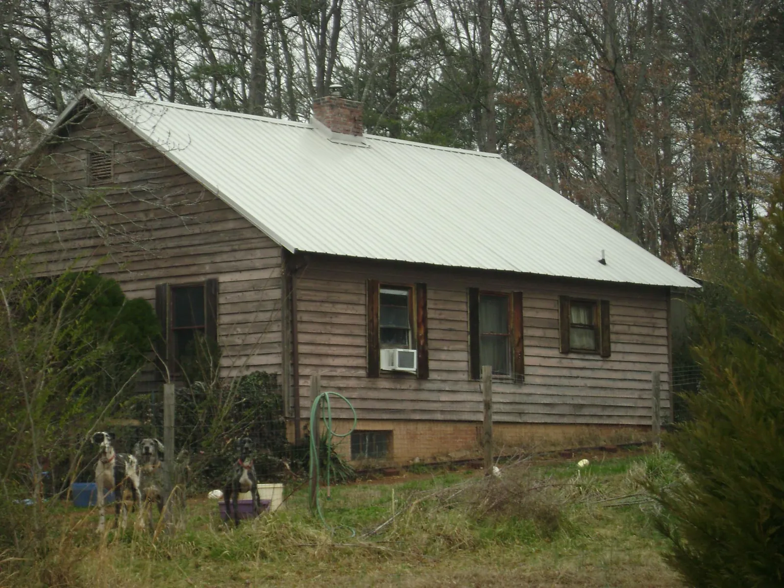 White metal roof on an old wood sided farmhouse, from a Metal Roof Installation job in Homer